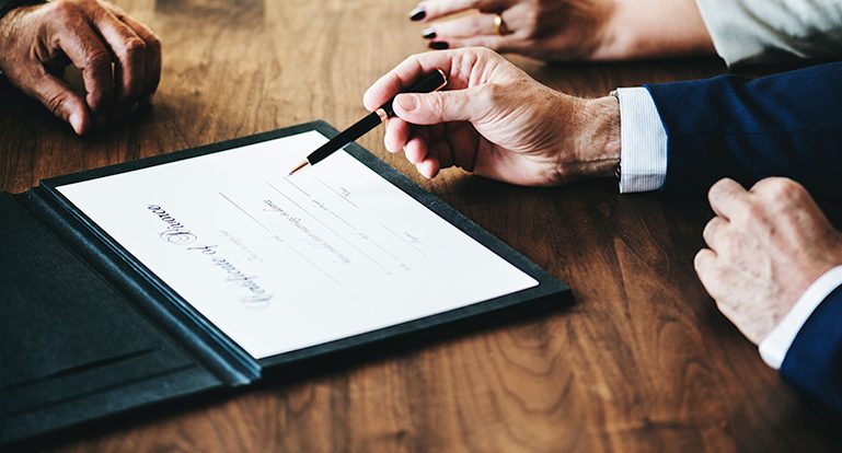 Lawyers looking over an award on a table.
