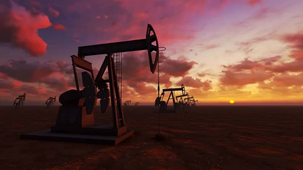 Oil field rig with a sunset in the background.