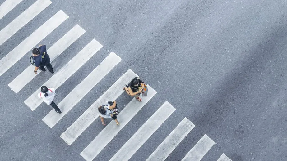 People walking across a pedestrian crosswalk.
