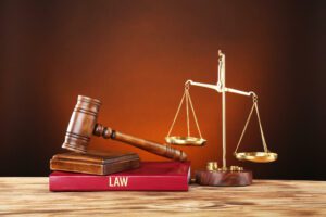 Judge gavel, scales and book on wooden table