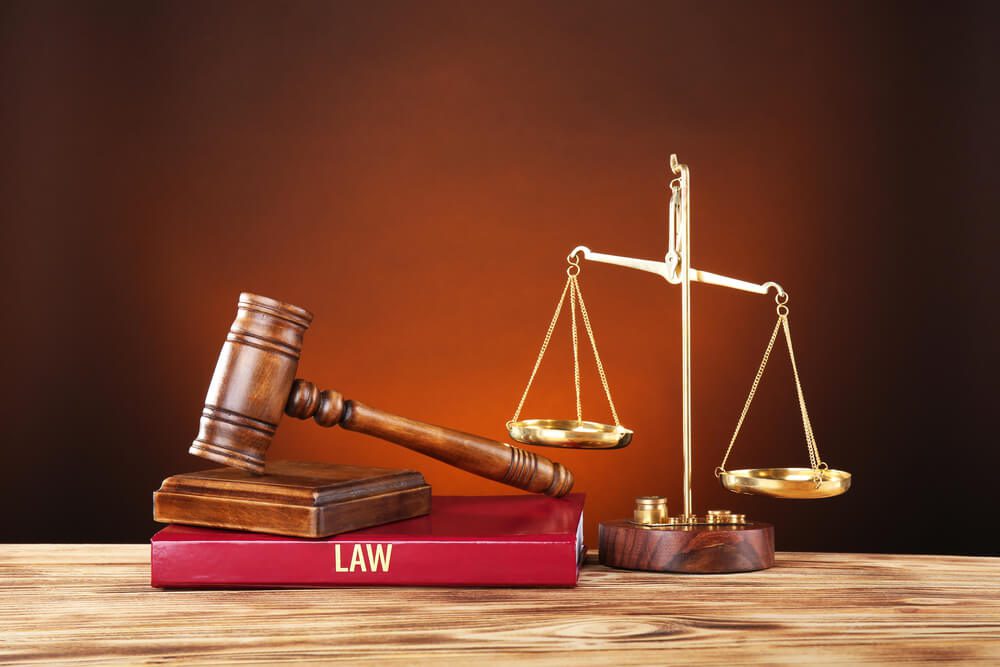 Judge gavel, scales and book on wooden table