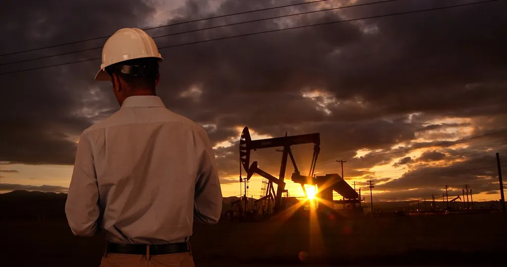 A worker standing on an oil field.