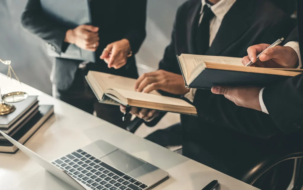 A group of lawyers looking over law books for a case.