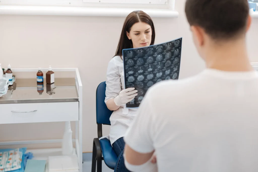 A doctor looking at MRI films with a patient present.