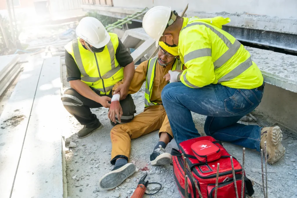 An injured construction worker on-site getting help.